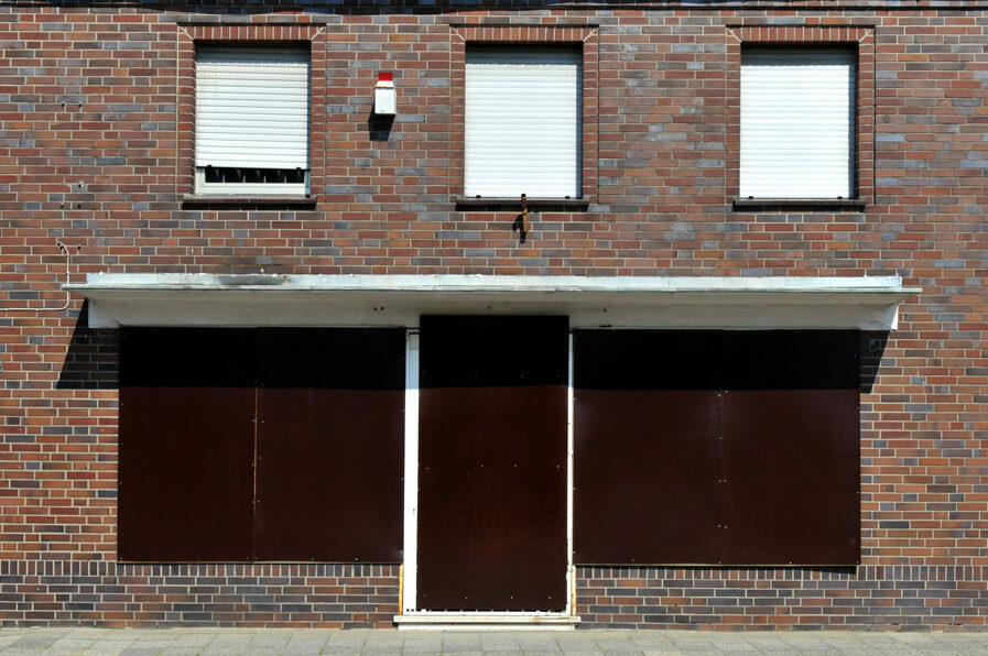 Backsteinfront mit verrammelten Türen und Fenstern